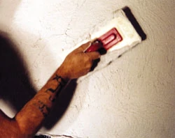 Use a plastic trowel on the finish coat. A plastic trowel makes it easier to achieve a uniform texture on the wall surface.