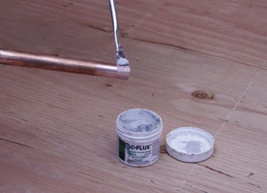 Apply flux to copper pipe and the interior of fittings with a small brush.