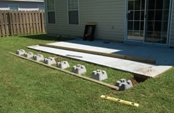 If your new deck will extend beyond the existing patio, lay out the pier blocks as needed.