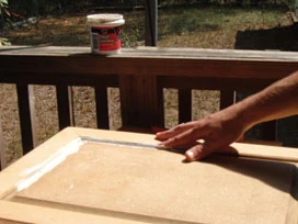 Smooth the hard-to-sand edges of MDF cabinets by applying a thin coat of vinyl spackling. Allow it to dry, remove any excess and you’re ready to prime.