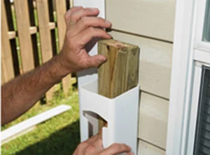 Inserting a pressure-treated 2x4 gives the vinyl newel post strength when anchored to the house framing.