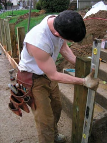 Once the posts were plumb and braced, we set each post in 80 pounds of concrete.