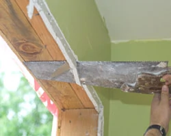 We use a shortened handsaw to trim the extra drywall from around the opening.