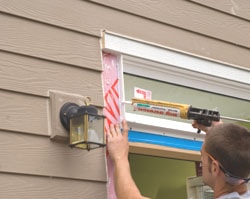 Caulk applied behind the trim boards seals where they meet the window, door jamb and siding.