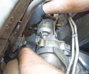 You may need to reach around the starter and go by feel to get one of the two bolts out. You can examine the yet-to-be-installed new starter for bolt locations to help you visualize what you can't see.