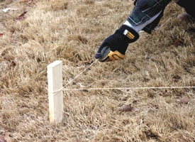 Pull the line tightly between corner stakes, then stake the line intermittently.