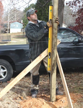 A traditional method to plumb and brace posts is to use a 4-foot level and a couple of pivoting wood legs.