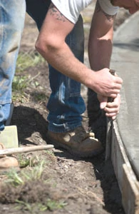 Shawn Joslin tests the concrete for washing. He feels for movement in the aggregate underneath. If it’s stable, it’s ready.