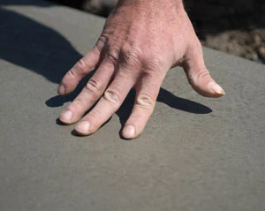 Removing stakes and form boards is an important step in preparing to expose the aggregate. Water must run freely off the edges of the walkway during washing.