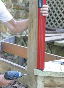 Plumb and square the posts, fastening to the joists with pairs of 1/2-inch diameter through-bolts and washers.