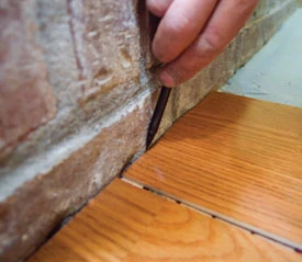 When marking the layout lines to cut an angle at the floor transition, be sure to put the flooring pieces in position as much as possible by placing the bottom edge of the groove on top of the tongue so the piece is marked in the same position as when the pieces are snapped together.