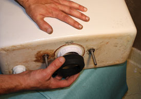 Install the base of the flush valve and apply the new tank-to-bowl gasket over the nut. Reinstall the tank.