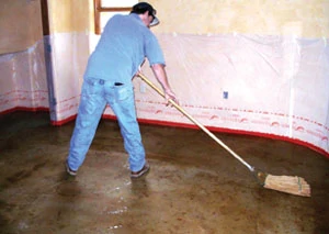 A worker uses a micro fiber mop for final rinsing during the post-stain scrub.