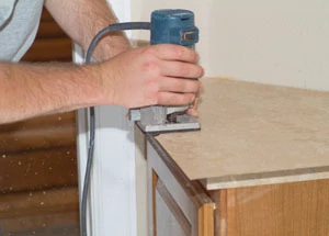 Once the laminate is thoroughly rolled, you can trim it with a router without delay.