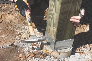 The galvanized post anchors from Simpson Strong-Tie elevate the bottom of the post about an inch off the surface of the footing to keep it away from standing water (www.strongtie.com).