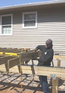 Deck joists are often supported by beams built from two large pieces of lumber, 2×8 or larger. The deck joists can be connected to the beam with metal hurricane brackets.