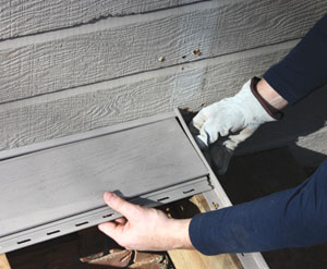 Installation begins with a starter strip fastened over the ledger board and an adjacent trim strip fastened to one of the rim joists, which conceals the ends of the deck boards.