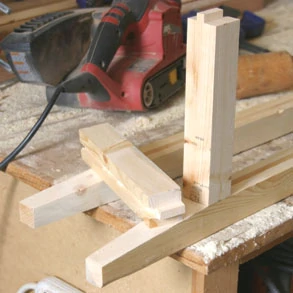 The side cross pieces have tenons cut in them to fit into the leg post dadoes. Cut using a tenoning jig in a table saw, a radial arm saw or by hand with a back saw.