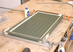 The beadboard panels are cut and their back edges routed or sawn to create a 1/4- inch thickness, then the doors glued together and clamped.