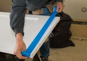 Protect the door surface with masking tape. This helps prevent the saw base from leaving marks on the door.