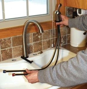 Shown is the valve/handle assembly that has three tubes: the faucet's hot and cold water lines, as well as the shorter valve outlet that interfaces with the solenoid.