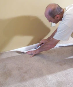 Proceed down the wall between the installed corners, anchoring the carpet and trimming the excess.