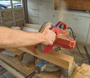 A miter saw is used to cut the newel post to length.