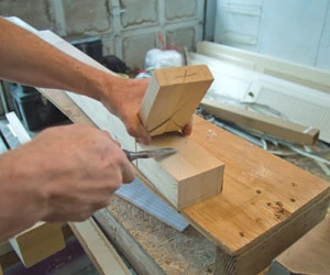 Use a wood chisel to snap the slabs off the side of the tenons and to finish cleaning up the cuts.