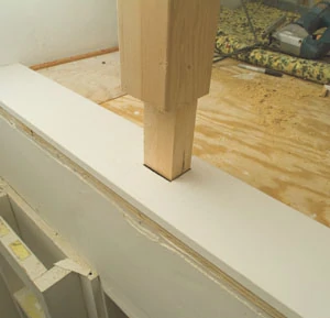 Note that the newel post tenon extends through the trim board and into the floor.