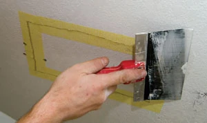 It's a good idea to begin your drywall patch before fastening the guardrail to the ceiling. This is an easier process with the rail out of the way.