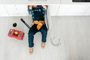 Plumber clearing clogged drain