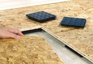 With some insulated subfloor systems, thin plastic shims help to level the subfloor on an uneven slab.