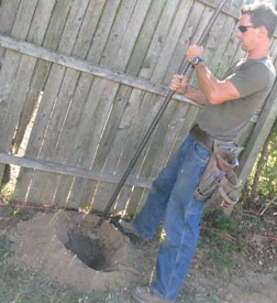 Tamp the soft earth with the blunt end of a digging bar.
