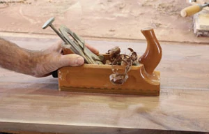 A hand plane can smooth the wood surface.