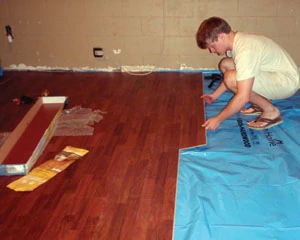 Laminate floors also require a plastic moisture barrier beneath the planks to prevent water damage. The tongue-and-groove flooring planks install easily with a snap-lock system.