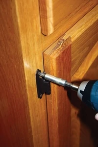 When installing doors, fasten the top hinge first.