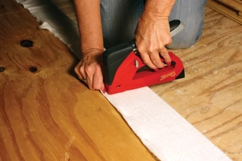 Wrap the batting tightly over the frame and fasten along the perimeter with a staple gun.