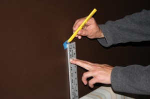 head16 Mark the midpoint on the wall, and map out the picture hook locations and D-ring hangers using this as a reference point.