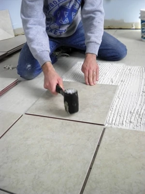 Use a rubber mallet to set the tiles into the mortar bed.