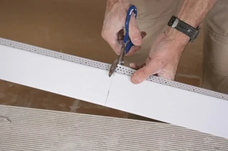 The angled edge of the tray ceiling will be created with a special vinyl bead called EZ-Tray manufactured by Trim-Tex Drywall Products. The angled edge is 3” wide. This angled bead is the piece that bridges the lower ceiling to the raised upper ceiling.