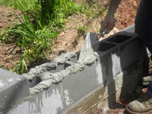 SANYO DIGITAL CAMERA Wet the dried concrete thoroughly, then use a trowel to apply the mortar and block. Remove excess mortar from the joints.