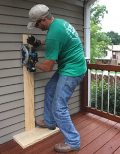 I used a 4-foot level to mark the plumb lines of the rough opening, then cut through the siding using a cordless circ saw with a homemade edge guide.