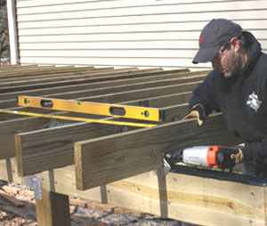 Après l'installation des solives, ajoutez un contreventement diagonal entre les poteaux et les solives pour stabiliser la terrasse. Utilisez une scie alternative pour couper le contreventement au niveau du sommet des solives.