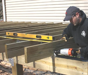 After the joists are installed, add diagonal bracing between the posts and joists to stabilize the deck. Use a recip saw to cut the bracing flush with the tops of the joists.