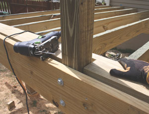 Utilizei um quebra-cabeças para entalhar a primeira fila de terraço para caber à volta dos postes, depois completei a superfície de caminhada utilizando 2x6's tratados como tábuas de terraço.'s as deck boards.