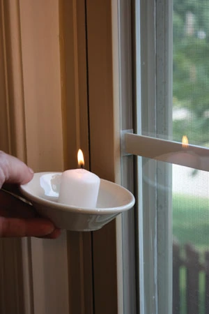 A simple way to check for air leaks is to use a burning candle or incense. Move the candle around the edges of doors and windows. Look for the smoke to flutter or flame to flicker, which indicates a leak.