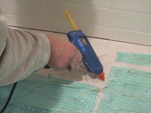 Hot glue can also be used to secure the mesh to the floor.