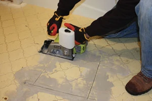 I opened the tile floor by cutting a square with an 18V Ryobi wet saw.