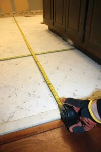 When laying out a tile floor, center the grid to eliminate small, fractional tiles at the perimeter of the floor.