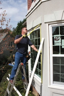 The windows are carefully measured to determine the length of the aluminum wrap. 